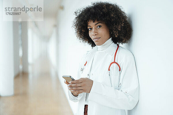 Arzt mit Mobiltelefon in der medizinischen Klinik
