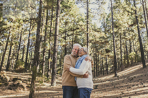 Glückliches älteres Paar  das sich im Wald umarmt
