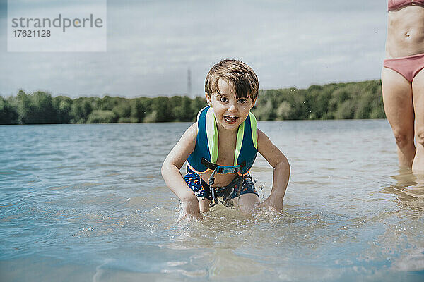 Fröhlicher Junge  der am Wochenende im See spielt