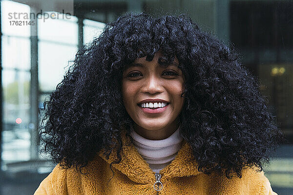 Lächelnde Frau mit schwarzem lockigem Haar