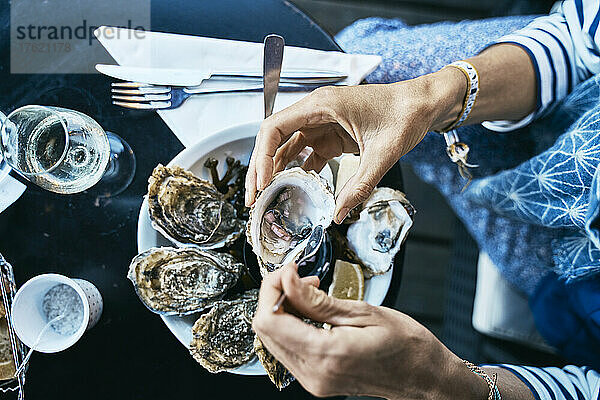 Woman having oysters at table