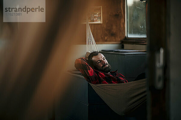 Bearded man lying in hammock on boat