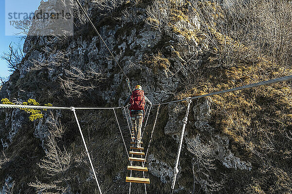 Wanderer überquert die Hängebrücke in den Bergamasker Alpen  Bergamo  Italien