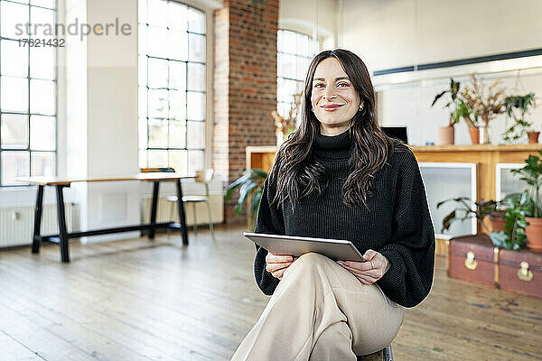 Glückliche Geschäftsfrau mit Tablet-PC im Heimbüro