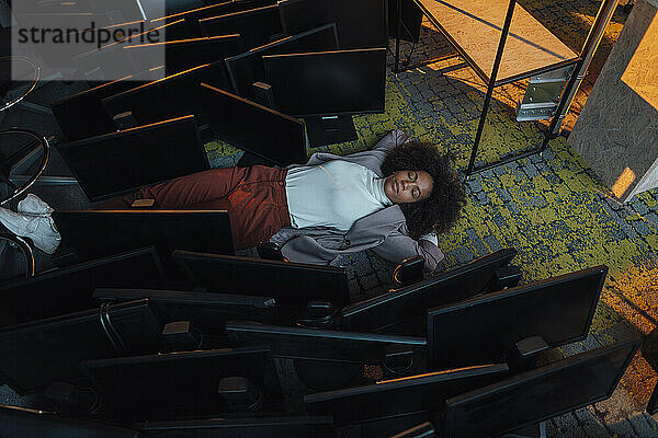 Businesswoman sleeping on floor in office