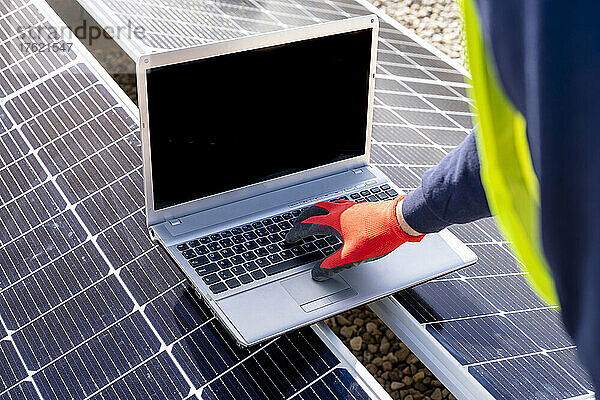 Techniker arbeitet am Laptop über Sonnenkollektoren