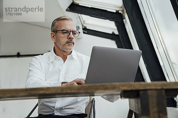 Geschäftsmann arbeitet am Laptop im Startup-Büro