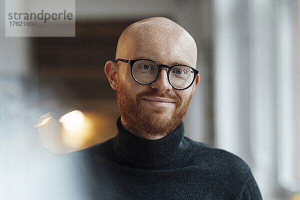 Lächelnder arbeitender Mann mit Brille im Büro