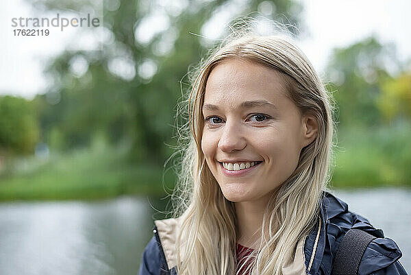Glückliche junge Frau mit blonden Haaren im Park