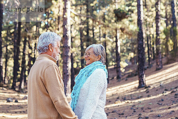 Glückliches älteres Paar  das einander im Wald anschaut