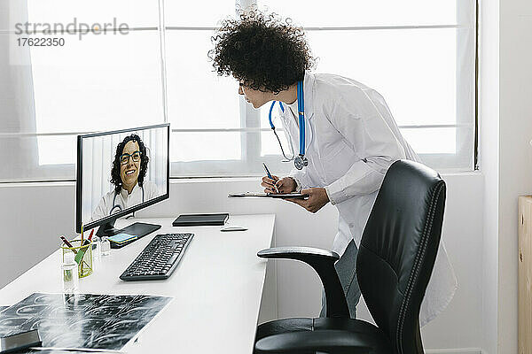 Arzt führt Videoanruf mit Kollegen über Desktop-PC in der medizinischen Klinik
