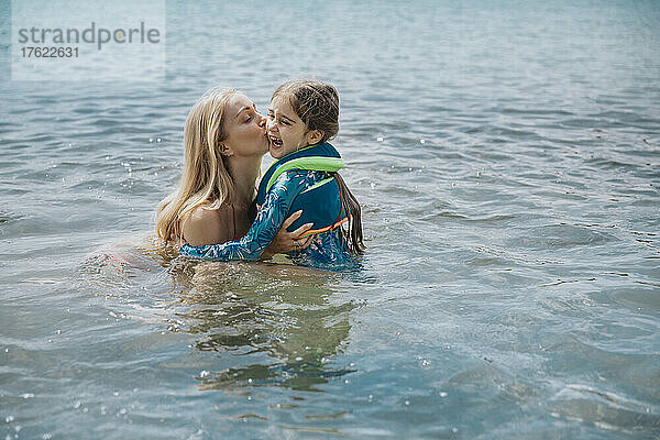 Mutter küsst Tochter am Wochenende im See
