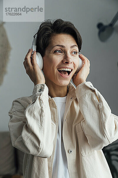 Cheerful woman with headphones listening to music