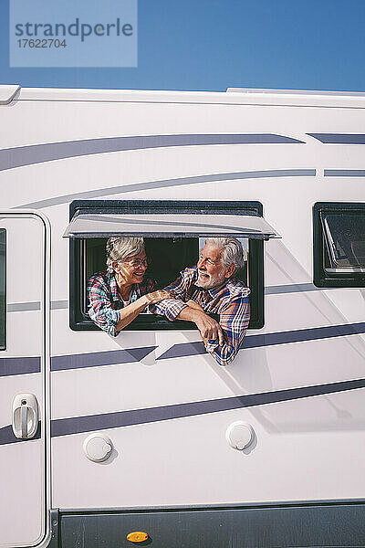 Senior couple looking through window of motor home