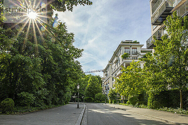 Deutschland  Bayern  München  Sonne scheint über einer leeren Straße in einem Wohngebiet
