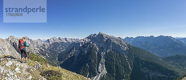 Wanderin bewundert im Sommer den Blick auf den Mittenwalder Höhenweg