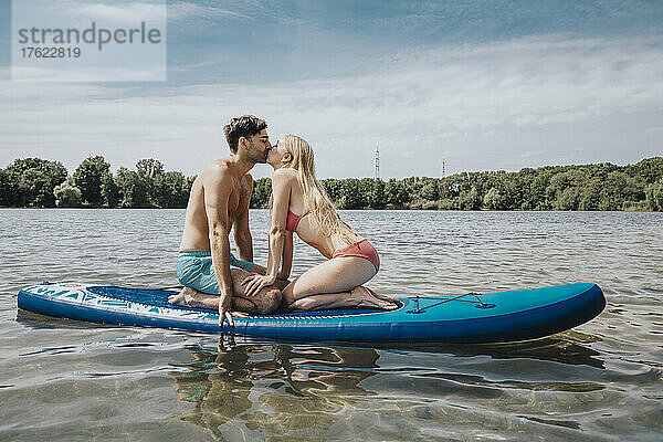 Paar küsst sich am Wochenende auf dem Paddleboard