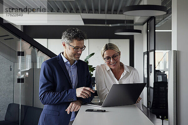 Geschäftskollegen teilen sich Laptop im Büro
