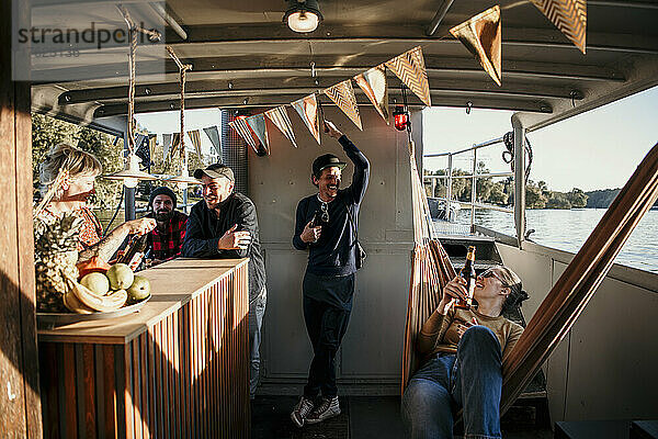 Lächelnde Freunde verbringen gemeinsam ihre Freizeit auf dem Boot