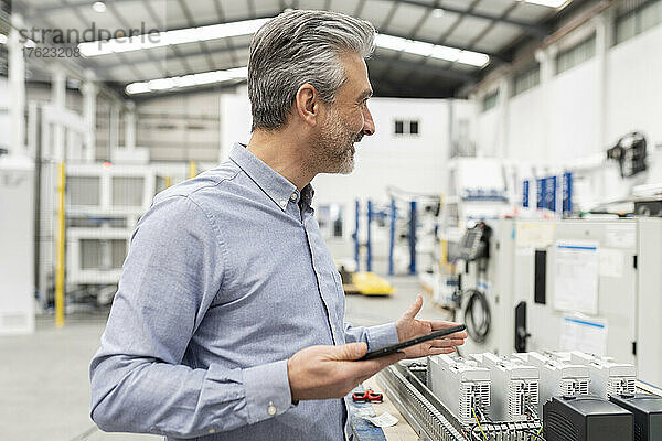 Ingenieur hält Tablet-PC in der Fabrik
