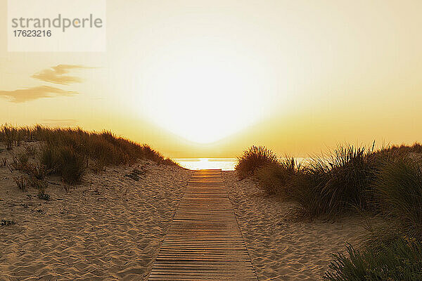 Promenade am Sandstrand bei Sonnenuntergang