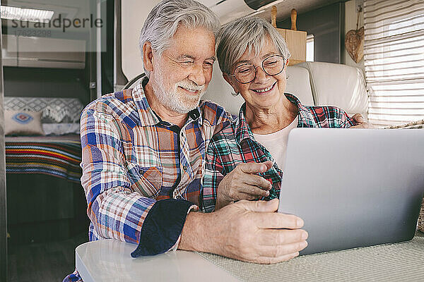 Glückliches Seniorenpaar benutzt Laptop im Wohnmobil