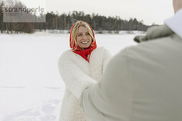 Cheerful blond woman enjoying with boyfriend in winter