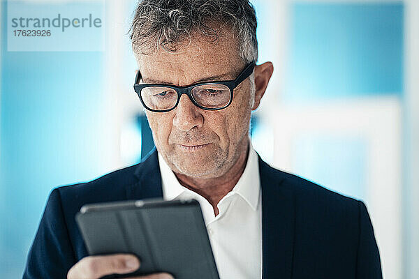 Geschäftsmann mit Brille und Tablet-Computer