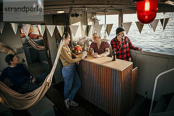 Happy friends spending leisure time together on boat