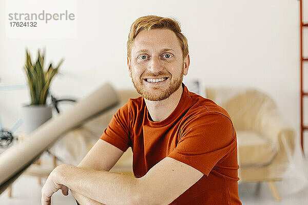 Happy young man with beard at home