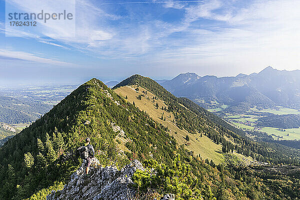 Männlicher Wanderer  der die Aussicht vom Gipfel des Aiplspitz-Berges bewundert