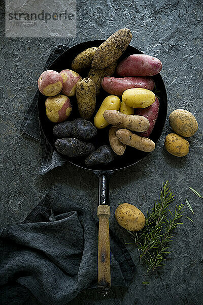Studio shot of frying pan with different varieties of raw potatoes