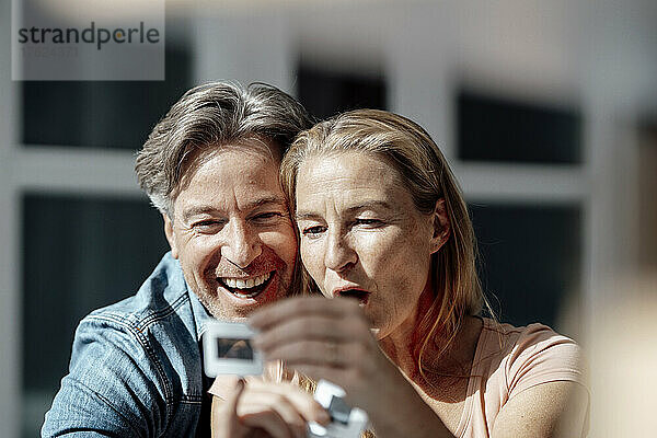Surprised couple looking at photographic slide