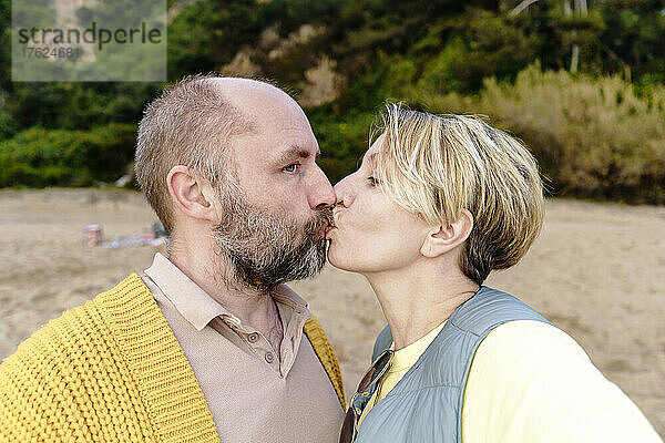 Mann und Frau küssen sich am Strand