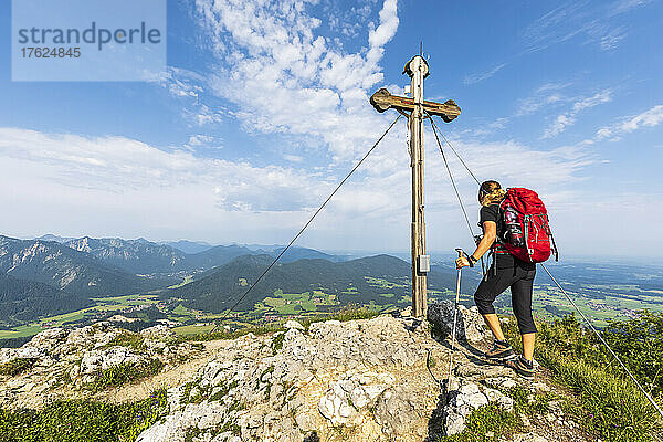 Female hiker standing in front of Bockstein summit cross