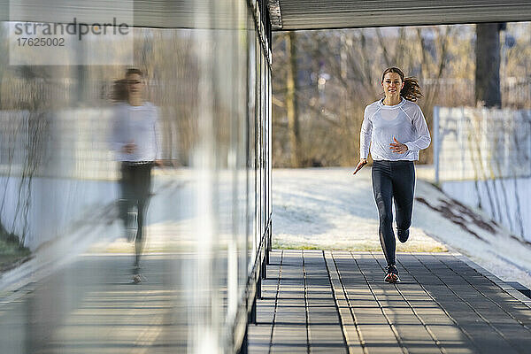 Frau in Sportkleidung joggt auf Fußweg