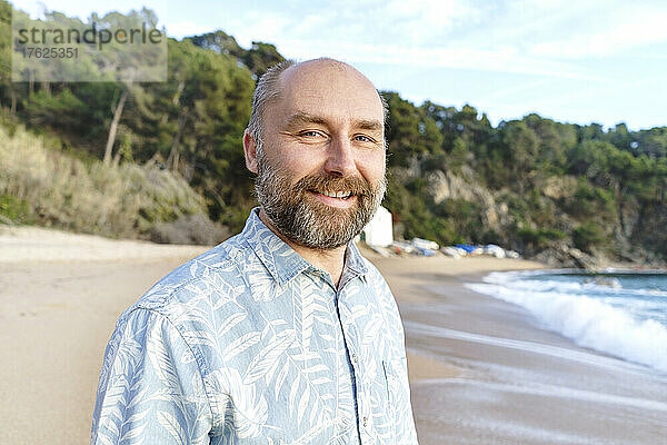Lächelnder Mann mit Bart am Strand