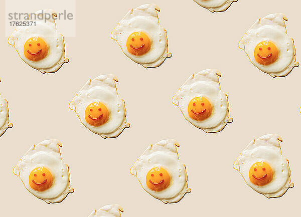 Fried eggs with anthropomorphic smiley faces on yolks