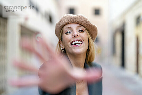 Cheerful blond woman wearing beret gesturing