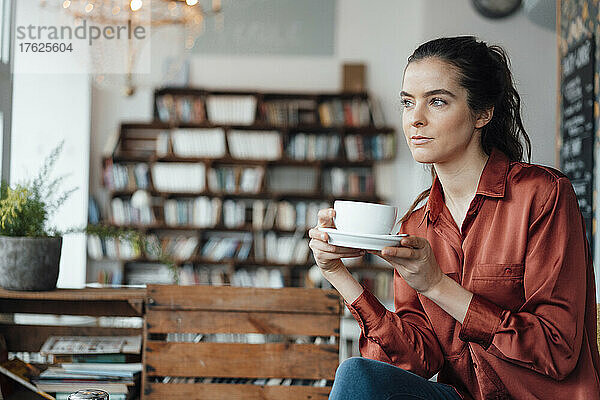 Nachdenkliche Frau trinkt Kaffee im Café