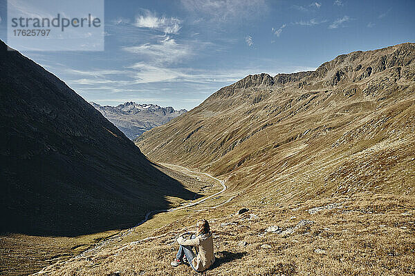 Tourist sitzt an Land am Berg im Urlaub  Timmelsjoch  Ötztaler Alpen  Österreich