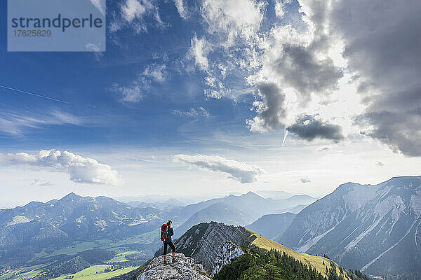 Wanderin bewundert die Aussicht vom Gipfel des Aiplspitz