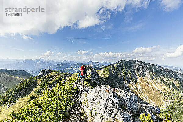 Female hiker walking along mountaintop of Aiplspitz