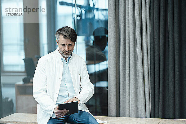 Medizinisches Fachpersonal nutzt Tablet-PC am Schreibtisch in der Klinik