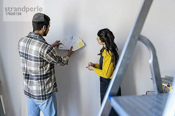 Young couple looking at color swatches in home renovation work