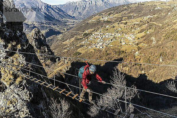 Adventurous man crossing Tibetan bridge  Orobie alps  Bergamo  Italy