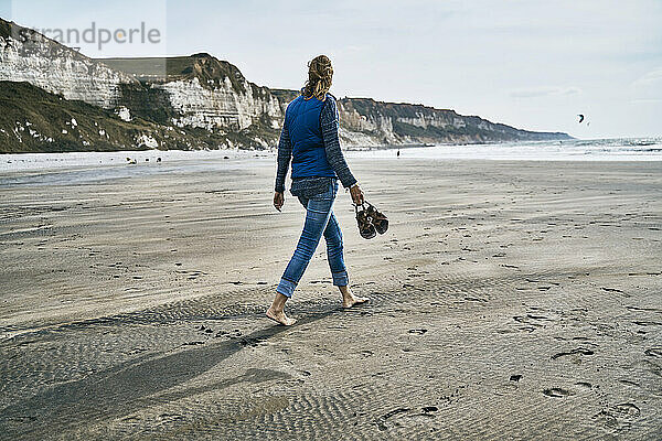 Tourist  der am Strand auf Sand spaziert