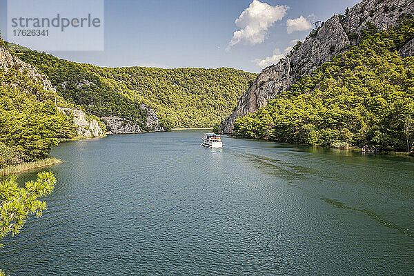 Schiff vertäut im Fluss inmitten von Bergen  Nationalpark Krka  Sibenik-Knin  Kroatien