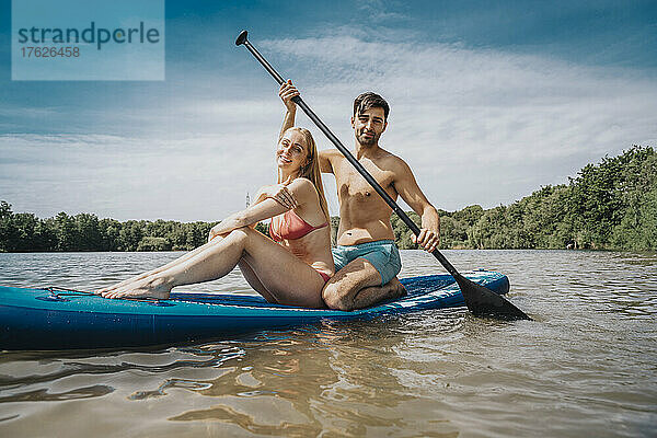 Mann paddelt mit Frau auf dem See
