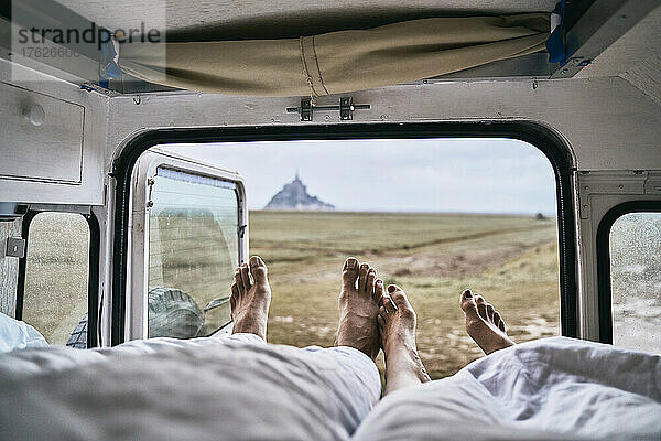Couple lying in camper van at vacation